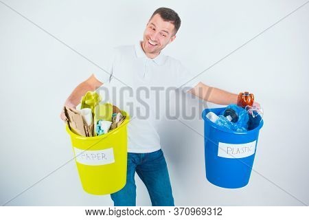 Young Man Isolated Over White Background. Guy Hold Heavy Colorful Buckets With Sorted Plastic And Pa
