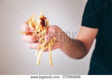 Young Man Isolated Over White Background. Close Up Picture Of Hand Holding French Fries Potato With 