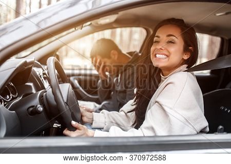 Driving Instruction. A Young Woman Learns To Drive A Car . Her Instructor Or Boyfriend Doesnt Like T