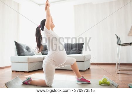 A Pregnant Woman Works Out On A Yoga Mat At Home. Pregnancy And Sports. Oga And Pilates For Pregnant