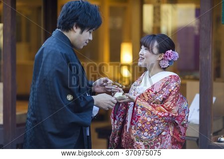 Kyoto, Japan - November, 8, 2019: Young Lovely Couple In Traditional Geisha Kimono Posing With Dango