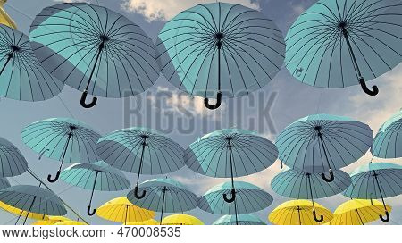 Umbrella Sky Background. Blue And Yellow Umbrellas Hanging Bottom- Up. Street Decoration