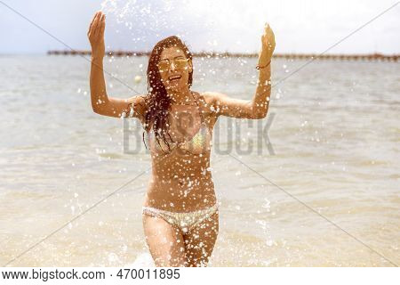 Sexy Young Woman Enjoying The Water Of The Caribbean Sea Under The Sun's Rays On The White Sandy Bea