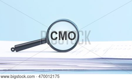 Magnifying Glass Written With Text Cmo Stands For Chief Marketing Officer, Blue Background