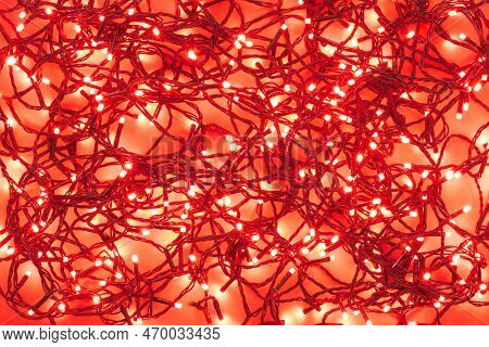 Tangled Wire Garlands With Red Light Bulbs On A Red Background