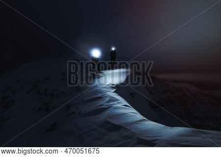 Mountaineers Trekking In The Cold Night At Liathach Ridge, Scotland