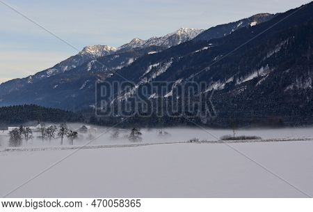 The Snowy Winter Landscape With Low Fog Near Pockau In Arnoldstein, Carinthia, Austria