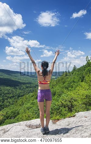 A Brunette With Arms Raised On The Summit Of Barrack Mountain In Falls Village Connecticut On A Sunn