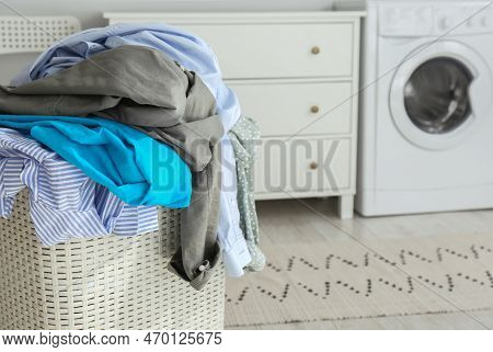 Plastic Laundry Basket Overfilled With Clothes In Bathroom, Closeup. Space For Text