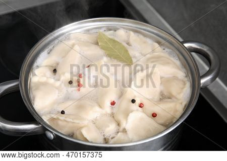 Cooking Dumplings (varenyky) With Tasty Filling, Peppercorns And Bay Leaf In Pot Indoors, Closeup