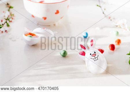 Close Up Funny Easter Eggs Containers With Bunny Ears Filled With Candy And Chocolate On The White K
