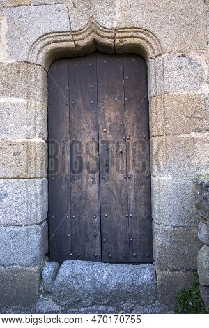 Wooden Door With Stone Mudejar Arch Bell Tower Of Santa Maria Church In Hervas Vertical