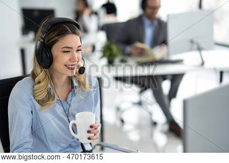 Portrait Of Dedicated Female Operator Agent Working At It Support Sector