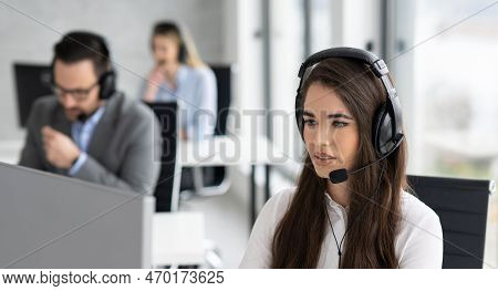 Portrait Of Dedicated Female Operator Agent Working At It Support Sector