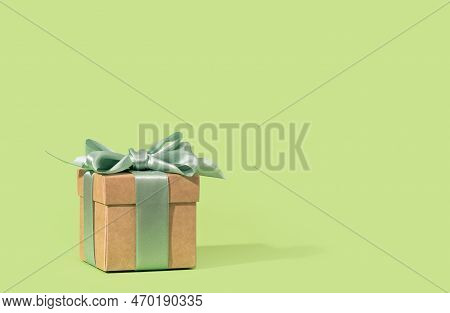 Buff Paper Gift Box With Green Ribbon Bow On Soft Green Background. Gift Or Holiday Concept. Mothers