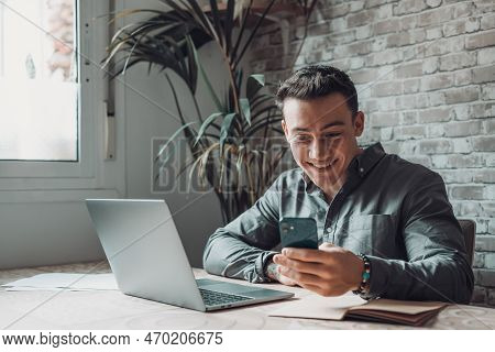 Confident Man Sitting At Desk Taking Break In Work With Electronic Documents On Laptop To Make Answe