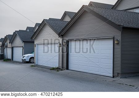 Row Of Garage Doors At Parking Area For Townhouses. Private Garages For Storage Or Cars In Rows In A