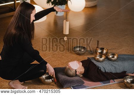A Young Beautiful Woman Is Doing A Massage With Singing Bowls And A Koshi Bell To Another Girl. Soun