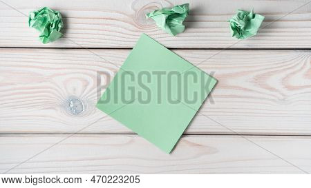 Flat Lay Of Blank Empty Green Sticker Sticky Note Near Crumpled Notes On Grey Wooden Table. Search, 