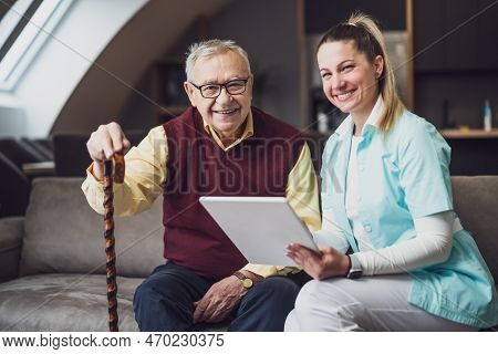 Nurse Home Caregiver Is Assisting Old Man At His Home. Professional Health Support For Elderly Peopl