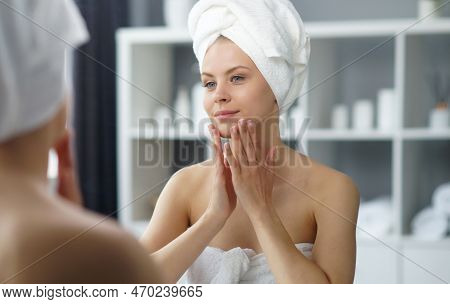 Young Woman Sits In The Bathroom In Front Of The Makeup Mirror And Does Cosmetic Procedures. Beautif