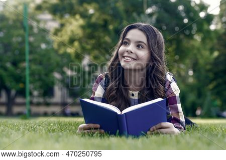 Let Your Creative Ability Investigate. Happy Child Read Book Lying On Green Grass. Reading Education