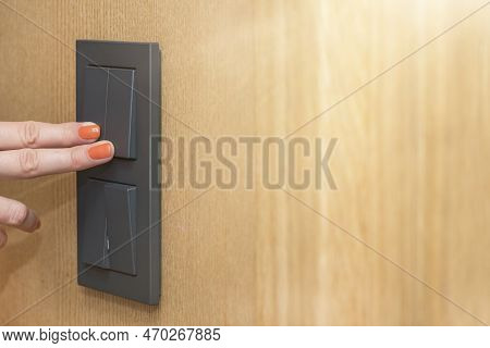 Turn On The Light, A Womans Hand Presses The Switch In The Apartment Close-up. Black Light Switch On