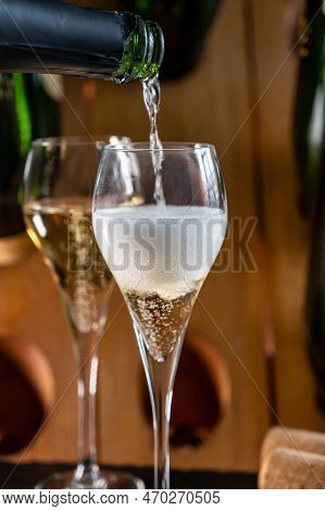 Glasses Of Sparkling White Wine Champagne Or Cava With Bubbles And Classic Wooden Champagne Pupitre