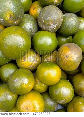 Green Colored Orange Fruits On Sale In A Market Stall