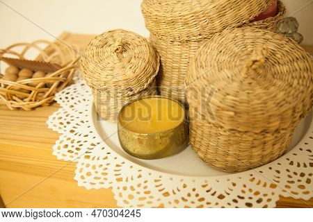 Gold Candle And Tinsha On A Wood Table.