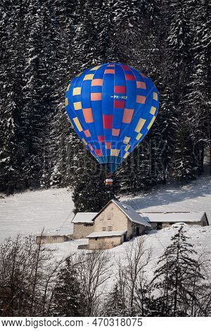 Chateau-d'oex,vaud, Switzerland - 23 January 2023: Hot Air Balloon Flying Over The House. Hot Air Ba