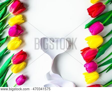 Colorfull Fresh Tulips Flowers With Ribbon Heart On White Background. Greeting Card For Valentine\\\