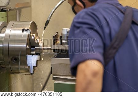 The Machine Operator Working With Lathe Machine. The Metalworking Process By Turning Machine.