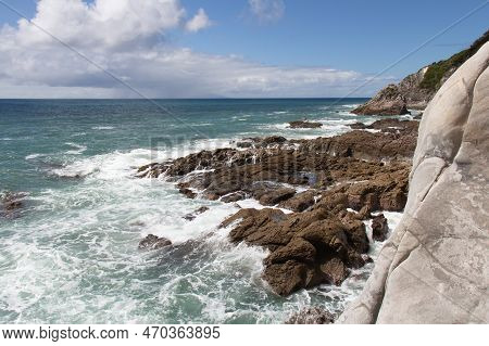 The View Of Rocky Coastline With Blue Sea And An Island On Background, Auckland, New Zealand.
