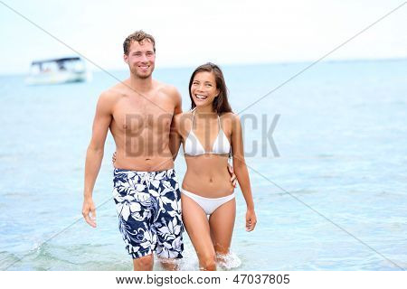 Strand paar in Liebe zu Fuß im Wasser, die Hand in Hand um einander genießen Sommerferien glücklich 