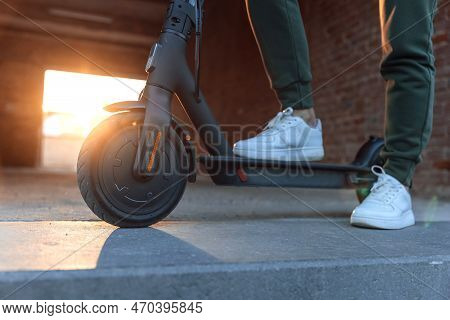Close Up View On Electric Scooter Front Wheel In Urban Sunny Street