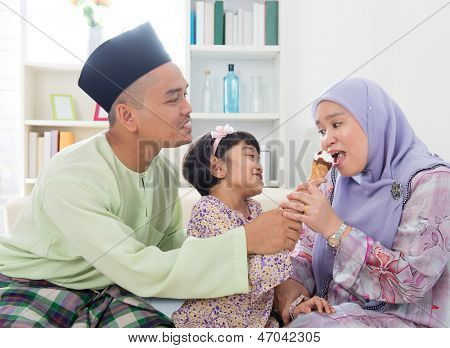 Fodring is. Muslimsk pige fodring mor en is. Smukke sydøstasiatiske familie levende 