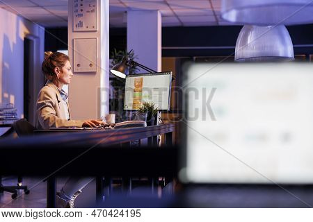 Laptop Computer With Company Investment Graph On Screen, Standing On Table In Startup Office. In Bac
