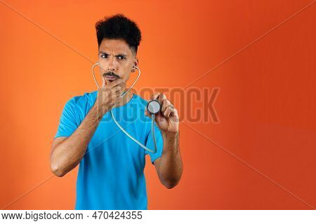 Doctor Or Veterinarian Isolated. Black Young Doctor Medical Resident With Stethoscope On Orange Back
