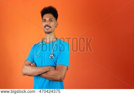 Doctor Or Veterinarian Isolated. Black Young Doctor Medical Resident With Stethoscope On Orange Back