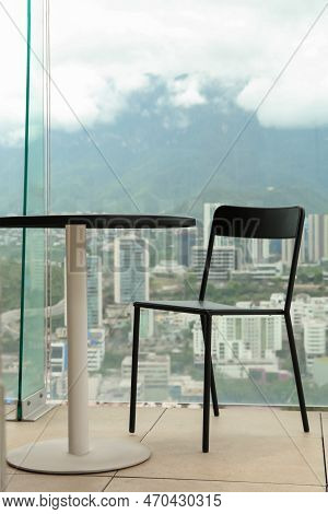Coffee Table And Chairs Against Picturesque Landscape Of City In Cafe