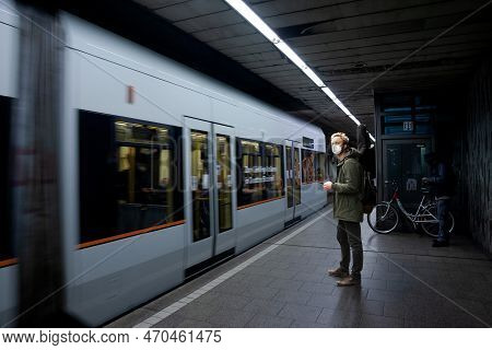 Cologne, Germany - November 6, 2022: Selective Blur On A Man Wearing A Facemask In Front Of A Blurre