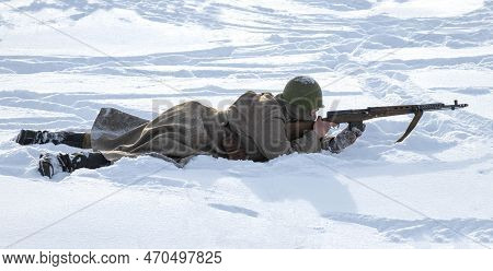 Krasnoe Selo, Russia - February 05, 2023: Soviet Soldier Lies In The Snow And Aims From A Tokarev Sv