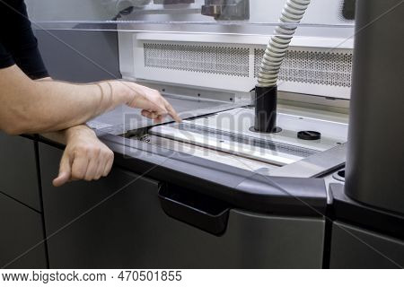 A Male Worker Stands Near The Powder Part Of A Powder 3d Printer And Points His Finger Of The Hand A