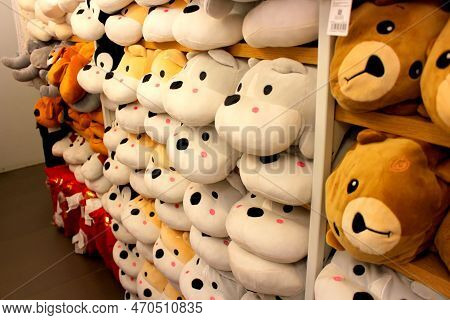 Stuffed White Dogs For Sale. Stuffed Smiling Dogs White And Brown In Color Arranged In A Shelf. Aisl