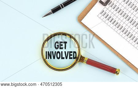 Get Involved Text On A Magnifier With Clipboard On Blue Background