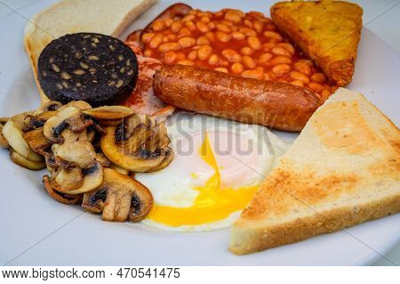 White Board With Full English Breakfast With Bacon, Fried Egg, Beans, Tomato, Roasted Sausage, Black