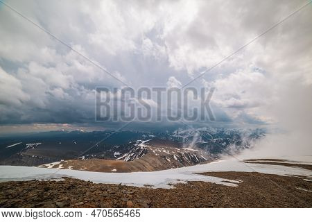 Awesome Top View Through Clouds To High Snowy Mountains. Scenic Landscape With Beautiful Snow Mounta