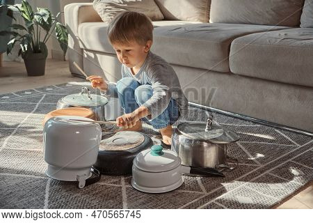 Child Drummer Having Fun Drum Playing On Kitchen Pans At Home