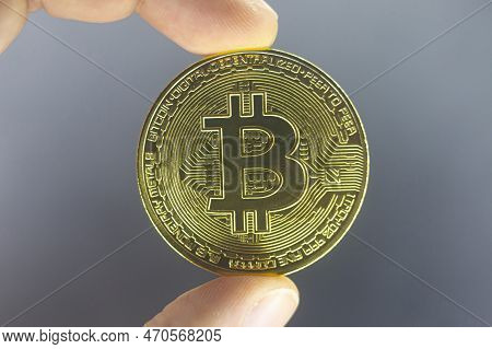 Finger Hold Bitcoin Golden On Black Isolated. Hand Hold Gold Bitcoin Crypto Ditital Money Concept. O